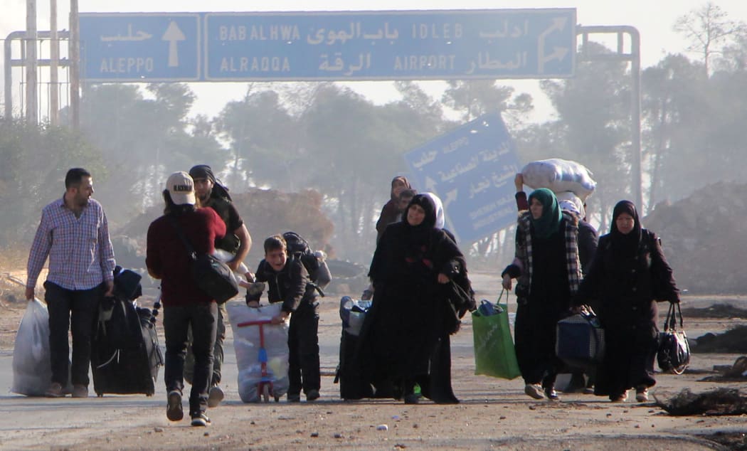 Syrians carry their belongings on October 30, 2016 as they leave Aleppo's southwestern frontline neighbourhood of Dahiyet al-Assad,