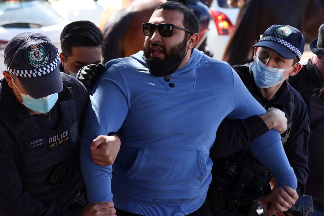 Police officers detain a protestor in Sydney today, following calls for an anti-lockdown protest rally. Protests were held in Sydney and Melbourne.