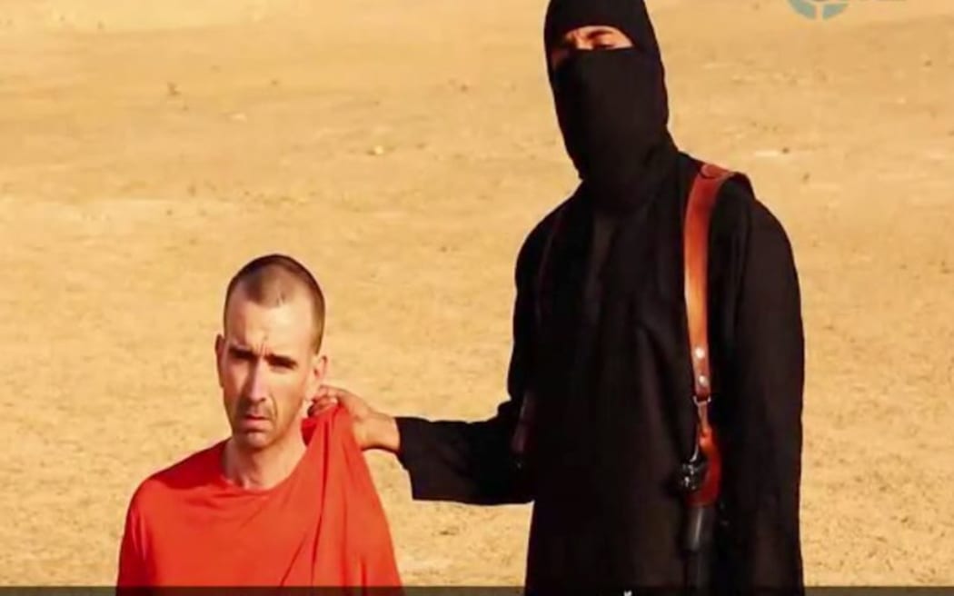 An image grab from a video released by Islamic State purportedly shows a militant threatening to kill David Haines.