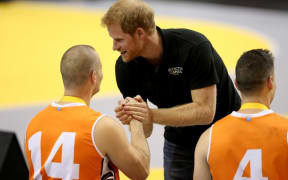 Prince Harry awards the silver medal to Walter Groen of the Netherlands on the podium at the medal ceremony for the Wheelchair Basketball final gold match.