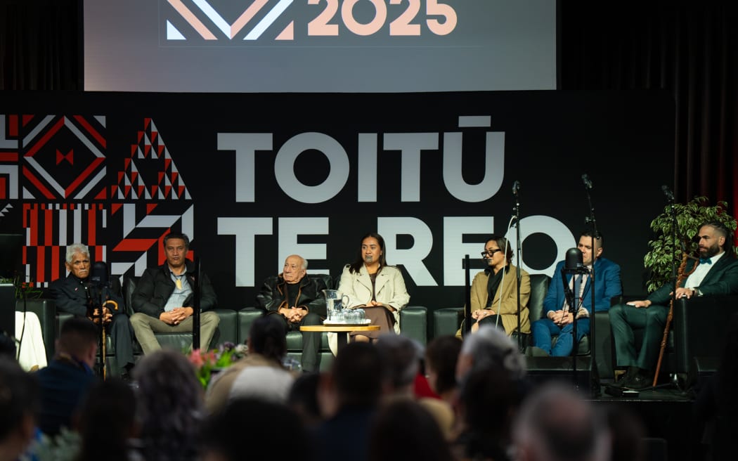 Te Arikinui Kuini Nga wai hono i te po on stage with Sir Tīmoti Kāretu and Bayden Barber.