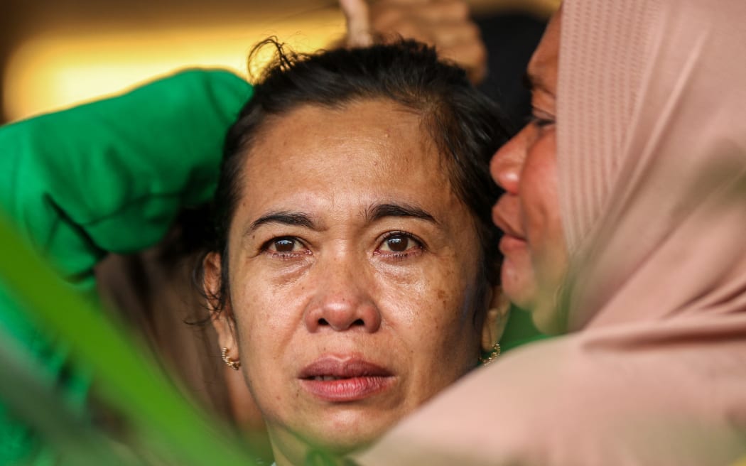 Family members and relatives wait for updates on the search operation of at least 61 people who were missing after a ferry sank off the popular Indonesian resort island of Bali, at Ketapang Port in Banyuwangi, East Java on July 3, 2025. (Photo by AFP)