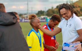 Former FIFA World Cup winner Christian Kerembeu presents a medal to a young Solomon island players at the OFC Under-15s Development Tournament in Auckland.