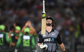 Colin Munro throws his bat in the air as he heads back to the dressing room after being dismissed.