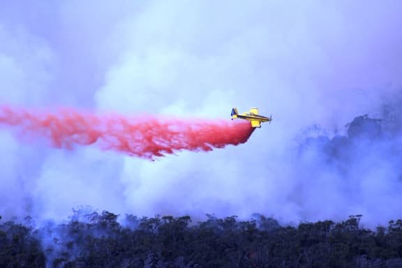 A plane dropping fire retardant material over bushfires in the Grampians in Victoria.