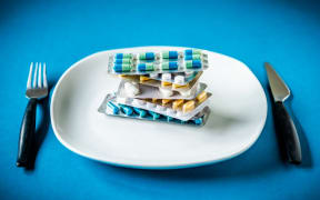 Capsules an pills in a plate. 
France (Photo by VOISIN / Phanie / Phanie via AFP)