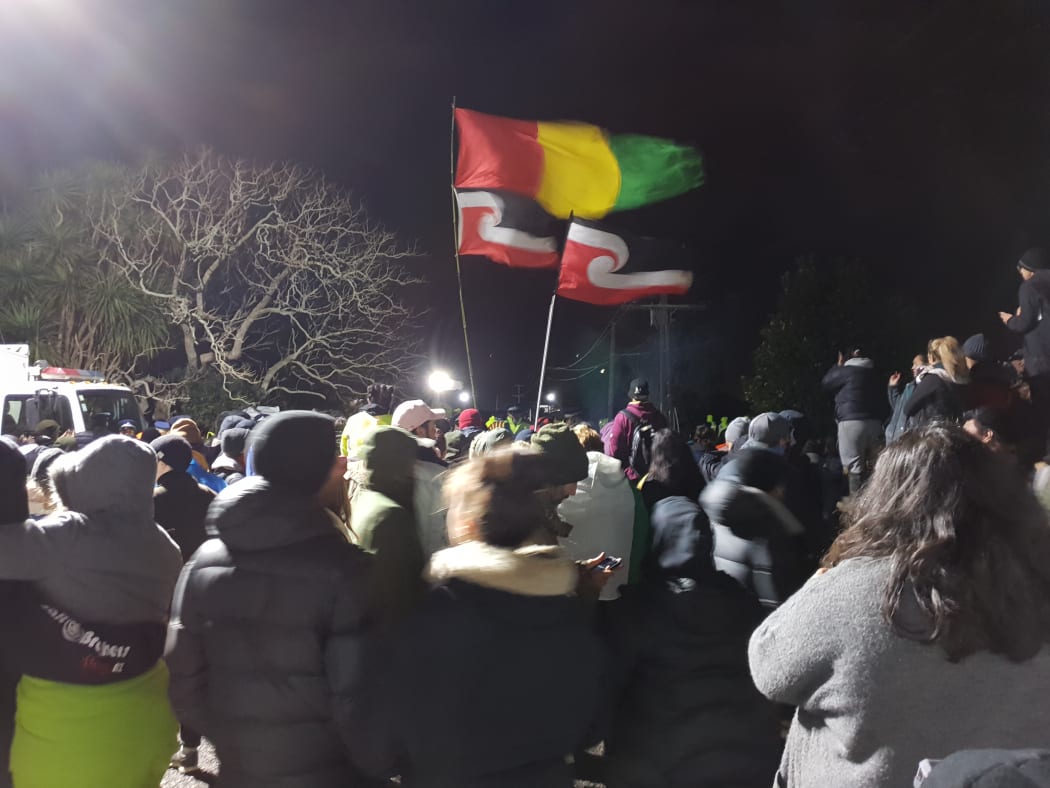 Flags fly at Ihumatao on Monday evening after police ramped up their presence.