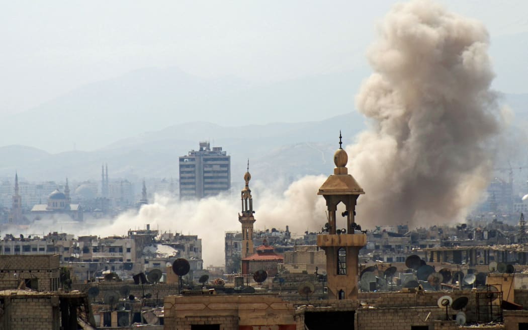Smoke billows following an air strike in Damascus.