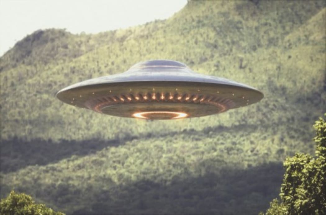 UFO (unidentified flying object) above trees, composite image. (Photo by KTSDESIGN/SCIENCE PHOTO LIBRARY / KTS / Science Photo Library via AFP)