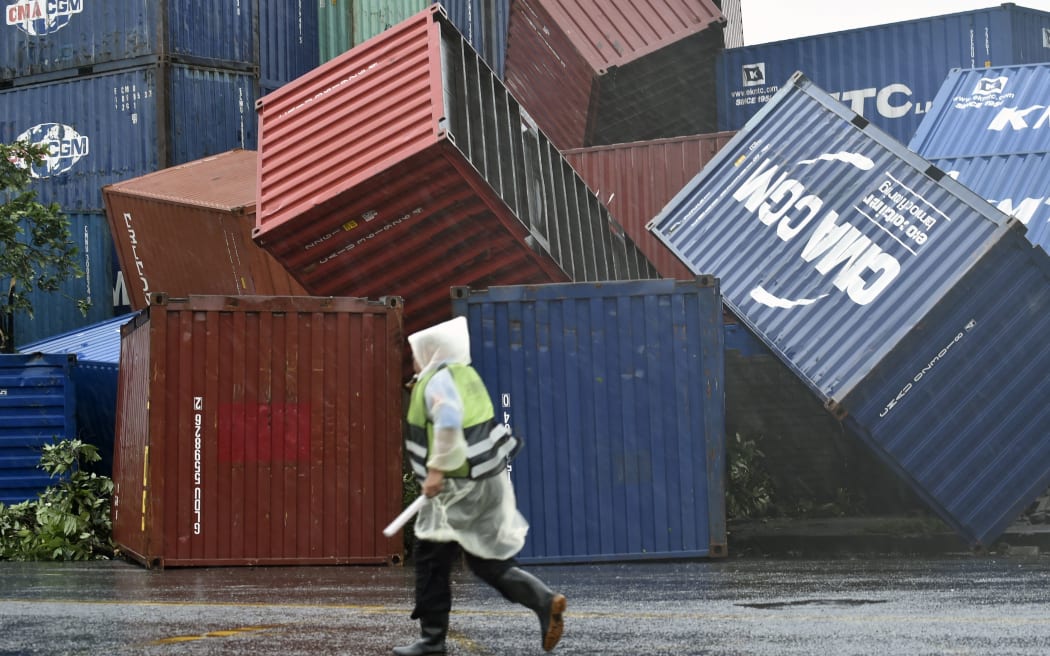 A man walks past downed shipping containers at the Kaohsiung Harbour as typhoon Meranti lashed southern Taiwan.