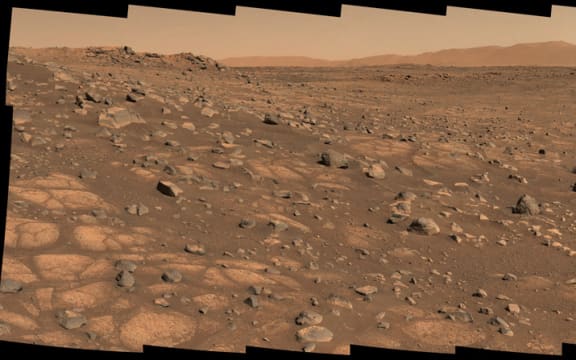 This Nasa photo taken 8 July 2021, shows the 'Cratered Floor Fractured Rough' geologic unit at Jezero Crater. A light-colored, paver stone, like the ones seen in this mosaic image, will be the likely target for first sampling by the Perseverance rover.