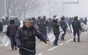 Riot police officers patrol in a street as unprecedented protests over a hike in energy prices spun out of control in Almaty on January 5, 2022.