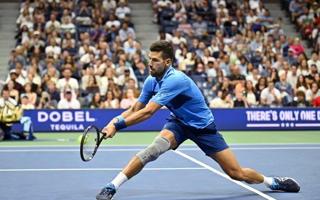 Serbia's Novak Djokovic plays a backhand return against Australia's Alexei Popyrin during their men's singles third round match on day five of the US Open tennis tournament at the USTA Billie Jean King National Tennis Center in New York City, on August 30, 2024. (Photo by ANGELA WEISS / AFP)