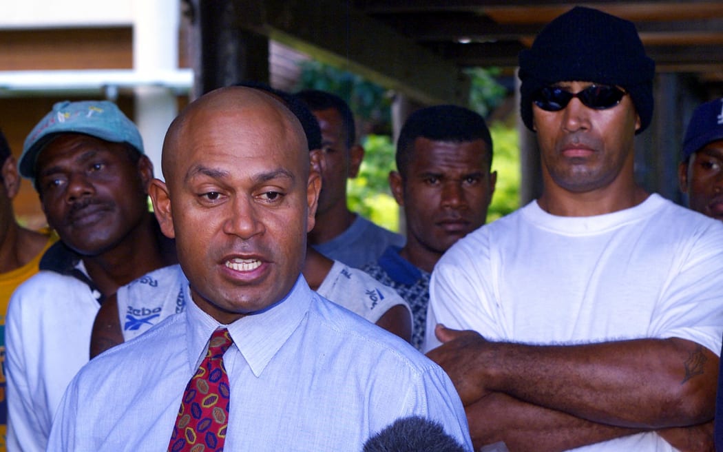 Coup leader George Speight is surrounded by bodyguards at Parliament House in Suva 03 June 2000 where former Fijian prime minister Mahendra Pal Chaudhry's government is being held hostage.  Both Speight and Fijian strongman Commodore Voreqe (Frank) Bainimarama are holding another round of talks after the military renegged on its offer to allow the Great Council of Chiefs to decide who should run the country.  (ELECTRONIC IMAGE)  AFP PHOTO/Torsten BLACKWOOD (Photo by TORSTEN BLACKWOOD / AFP)