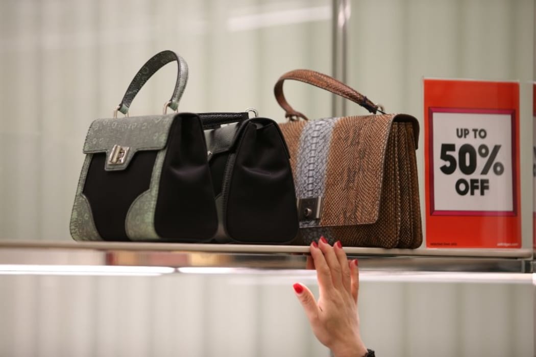 Customers look at handbags at Selfridges department store in central London, on December 26, 2016, during the post-Christmas, Boxing Day sales.