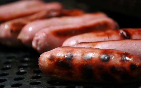 Pork sausages on a barbecue.