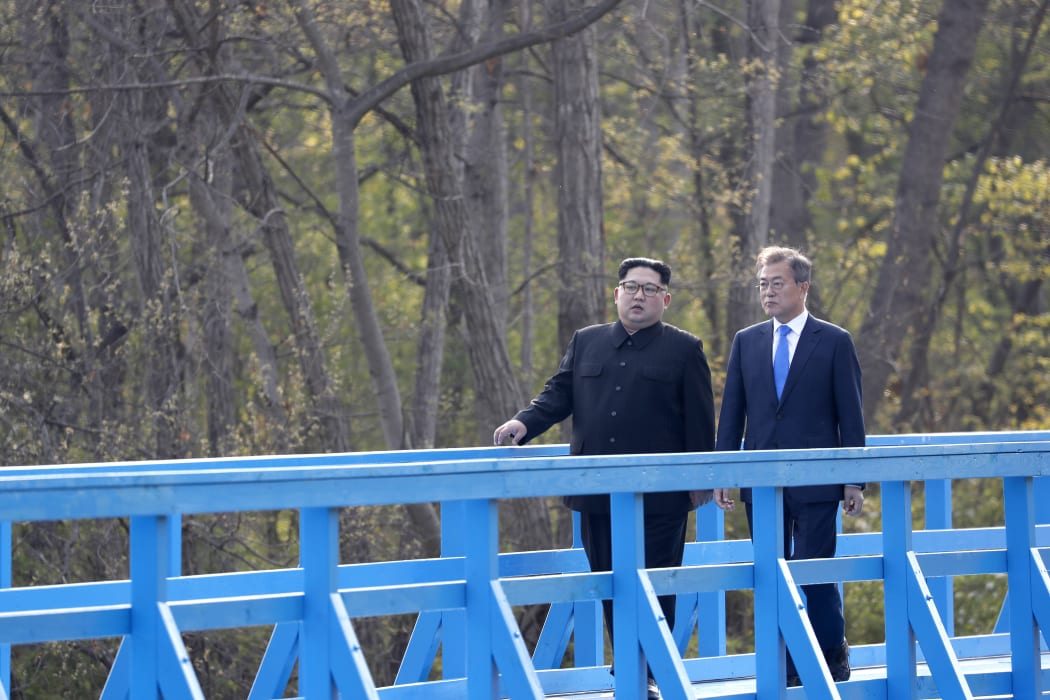 North Korea's leader Kim Jong Un (L) and South Korea's President Moon Jae-in (R) walk on a bridge after a tree-planting ceremony at the truce village of Panmunjom
