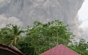 This handout picture taken and released on December 4, 2021 by Indonesia's National Board for Disaster Management (BNPB) shows Semeru volcano spewing ash into the air during an eruption as seen from Lumajang. (