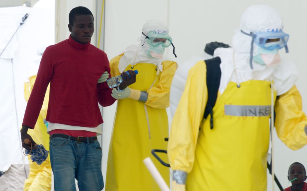 Health workers wearing protective gear with a potentially contaminated patient in Monrovia this week.