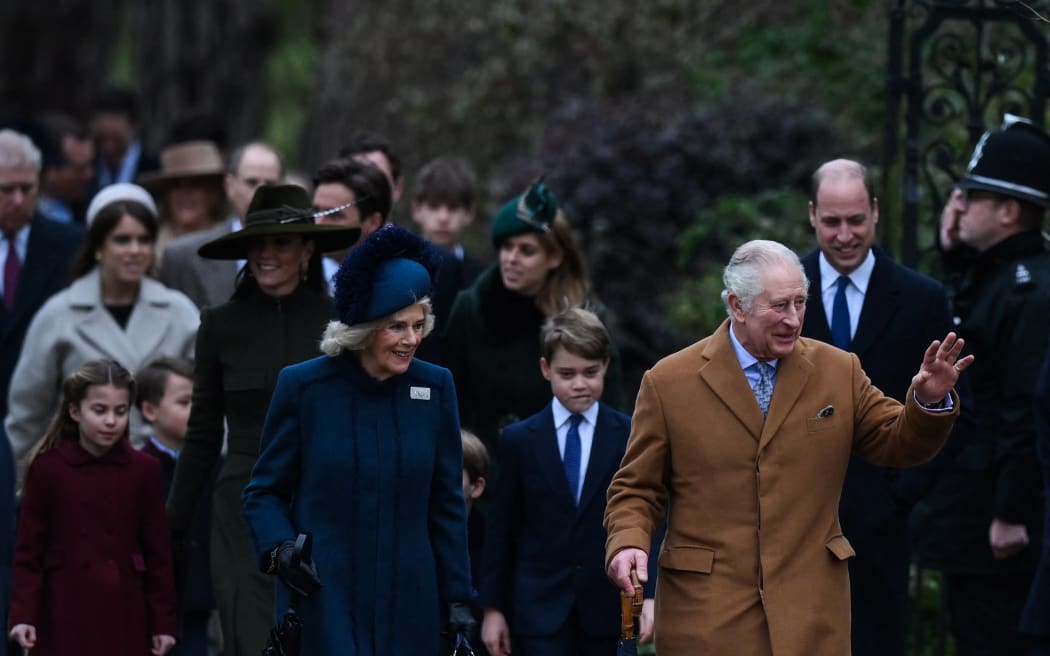 King Charles III (right) flanked by Camilla, Queen Consort (left), waves to members of the public as he arrives for the royal family's traditional Christmas Day service at St Mary Magdalene Church in Sandringham, Norfolk, eastern England, on 25 December, 2022.
