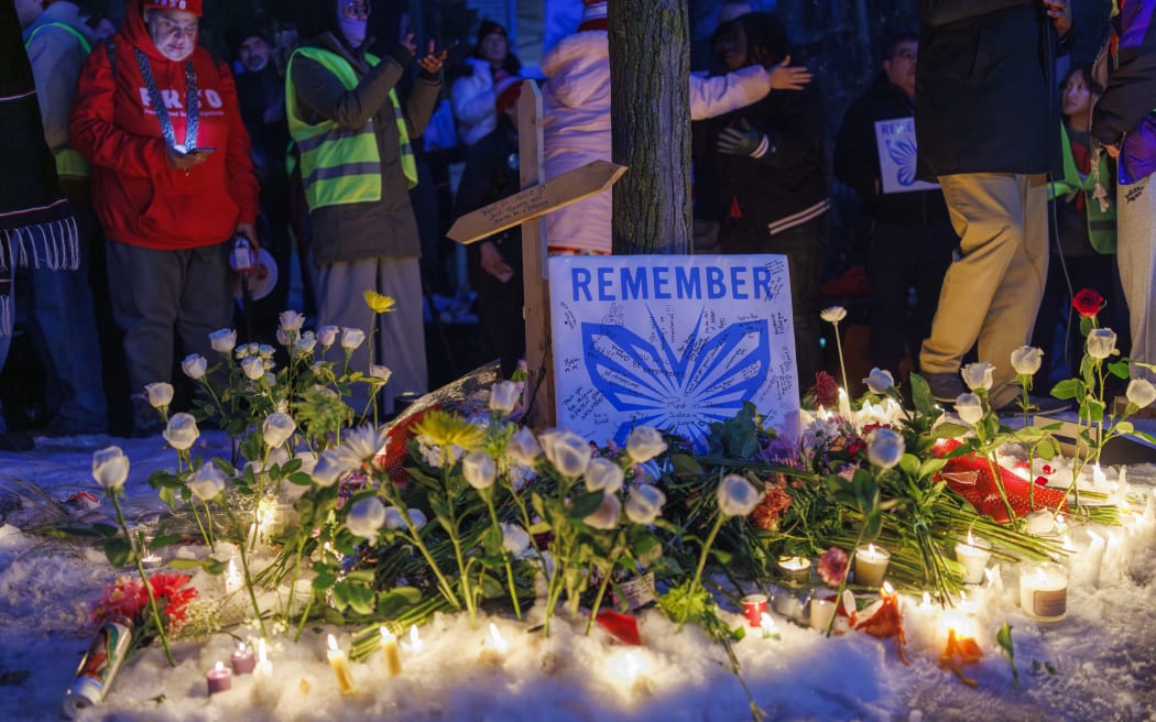 People demonstrate during a vigil at the site where a woman was shot and killed by an immigration officer earlier in the day in Minneapolis, Minnesota, on January 7, 2026. An immigration officer in Minneapolis shot dead a woman Wednesday, triggering outrage from local leaders even as US President Donald Trump claimed the officer acted in self-defense. Minneapolis Mayor Jacob Frey deemed the government's allegation that the woman was attacking federal agents "bullshit," and called on Immigration and Customs Enforcement (ICE) officers conducting a second day of mass raids to leave Minneapolis. (Photo by Kerem YUCEL / AFP)
