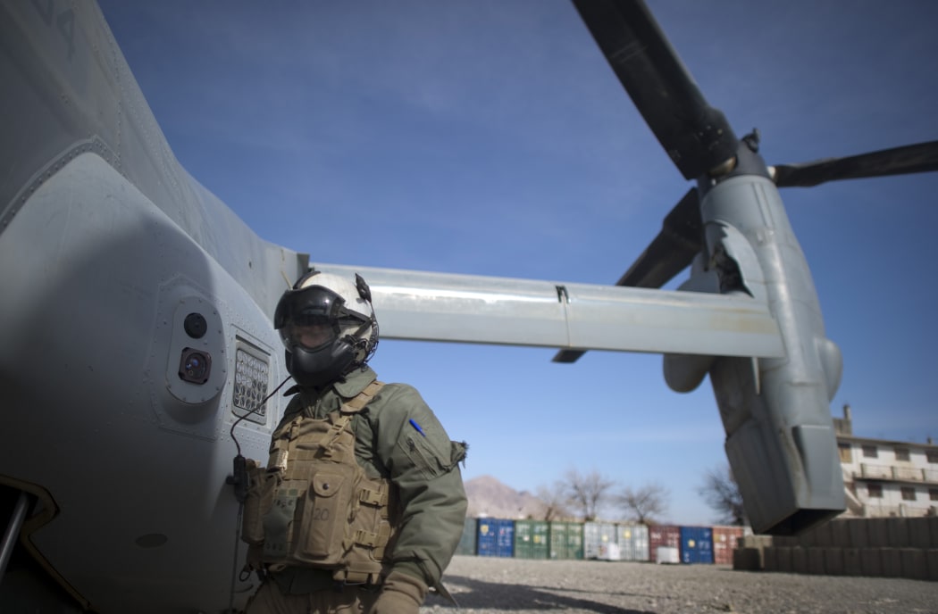 A Marine corps helicopter crew member waits as a helicopter lands at Musa Qala District centre base in Helmand province on January 27, 2011.