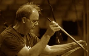Dr John Egenes playing the musical saw