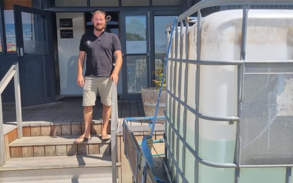 Restaurant Wharf owner and manager Grant Fussell drove a trailer to work with a 1000-litre drum of his home tank water.