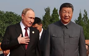 In this pool photograph distributed by the Russian state agency Sputnik, Russia's President Vladimir Putin (L) walks with China's President Xi Jinping before a military parade marking the 80th anniversary of victory over Japan and the end of World War II, in Beijing’s Tiananmen Square on September 3, 2025. (Photo by Alexander KAZAKOV / POOL / AFP)