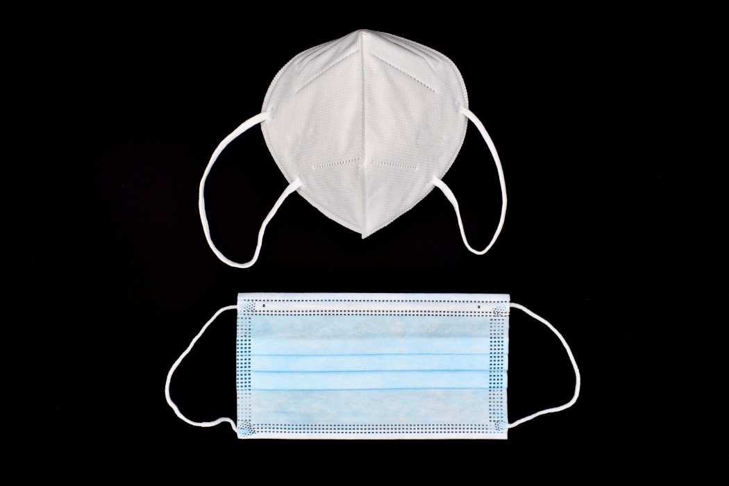 Disposable KN-95 mask vs thin surgical mask. COVID-19 prevention. H1N1, H5N1 safety measures. Isolated on black background.