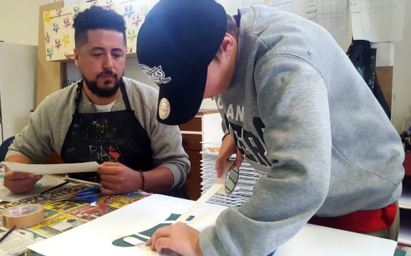 Teacher Jermaine Reihana works with a student.