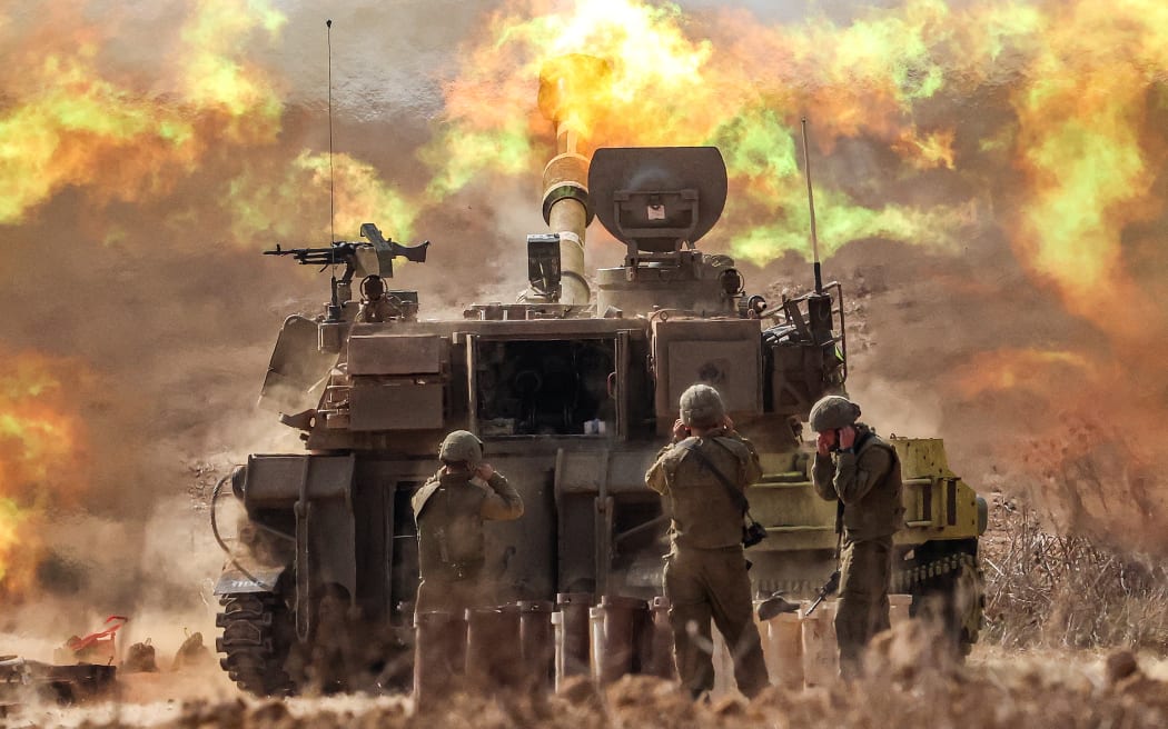 An Israeli army self-propelled howitzer fires rounds near the border with Gaza in southern Israel on October 11, 2023. Israel declared war on Hamas on October 8 following a shock land, air, and sea assault by the Gaza-based militant group. The death toll in Israel has surged above 1,200 following the worst attack in the country's 75-year history, while Gaza officials have reported 1000 people killed so far. (Photo by JACK GUEZ / AFP)