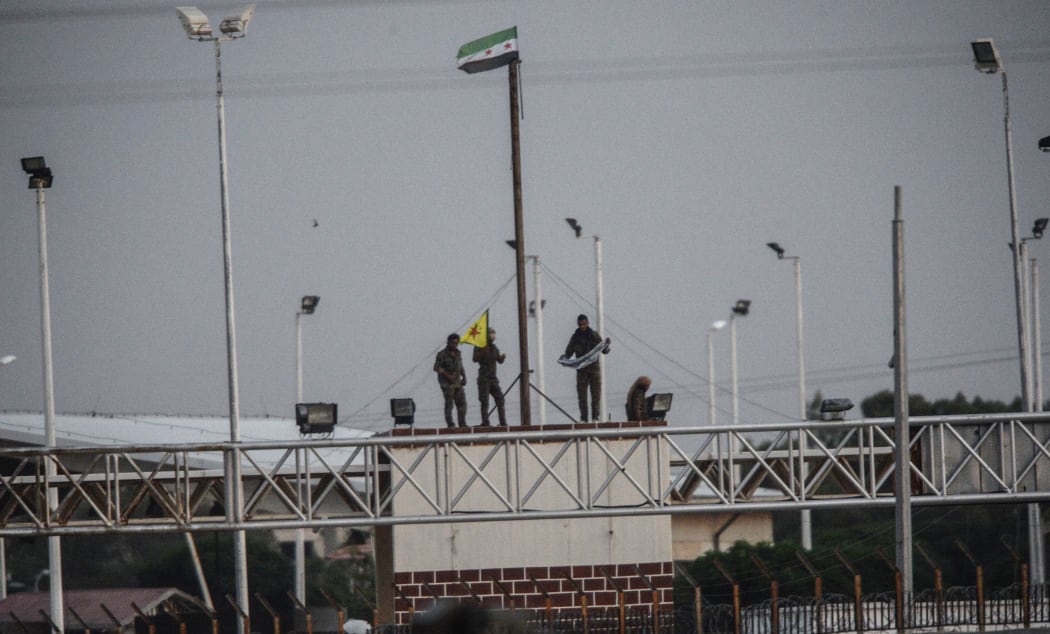 YPG fighters hold their movement's flag.