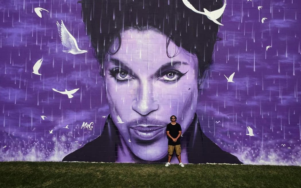 Artist Graham Hoete with his massive Prince wall mural.