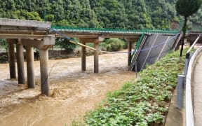 (240720) -- ZHASHUI, July 20, 2024 (Xinhua) -- This photo taken on July 20, 2024 shows the site of a bridge collapse in Zhashui County in Shangluo City, northwest China's Shaanxi Province.
  Eleven people were confirmed dead as of Saturday morning following the partial collapse of a highway bridge in northwest China's Shaanxi Province, local authorities said.
  The bridge, located in Zhashui County in Shangluo City, collapsed at approximately 8:40 p.m. on Friday due to a sudden downpour and flash floods, according to the provincial publicity department.
  By 10 a.m. on Saturday, rescue teams had recovered five vehicles that had fallen into the river. Rescue operations are underway. (Xinhua) (Photo by Liu Xiao / XINHUA / Xinhua via AFP)