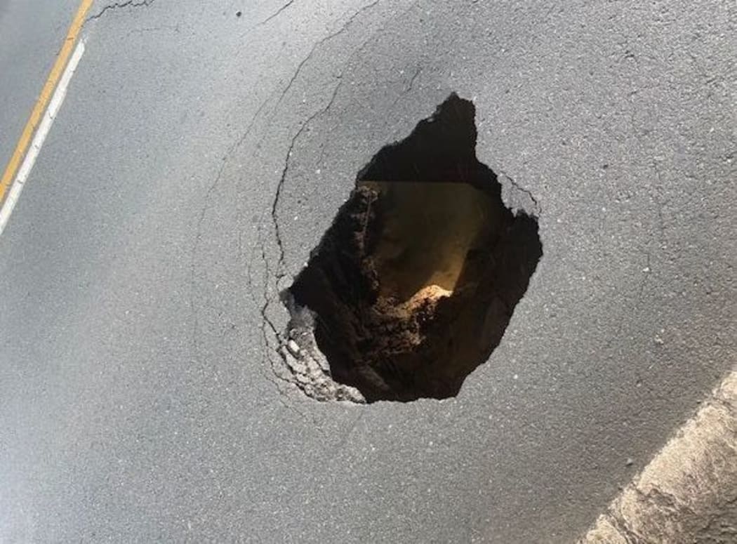 The hole in the road.
