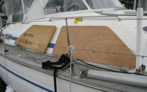 Plywood storm coverings in position, but not secured over windows, on a Bavaria Oceans 47 sister ship.