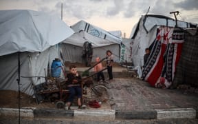 Displaced Palestinian children play outside their tent in the port of Gaza City, Palestine, on November 16, 2025. (Photo by Majdi Fathi/NurPhoto) (Photo by MAJDI FATHI / NurPhoto via AFP)