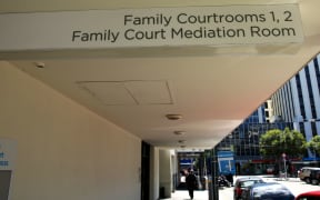 An exterior shot of a Family Court and mediation room, showing a sign pointing to the courtrooms and a street in the background.