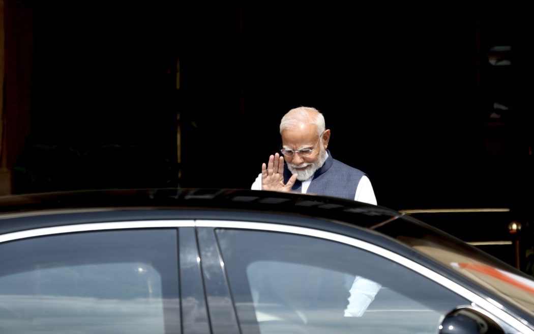 Indian Prime Minister Narendra Modi signs to Christopher Luxon when he arrives at Hyderabad House in New Delhi