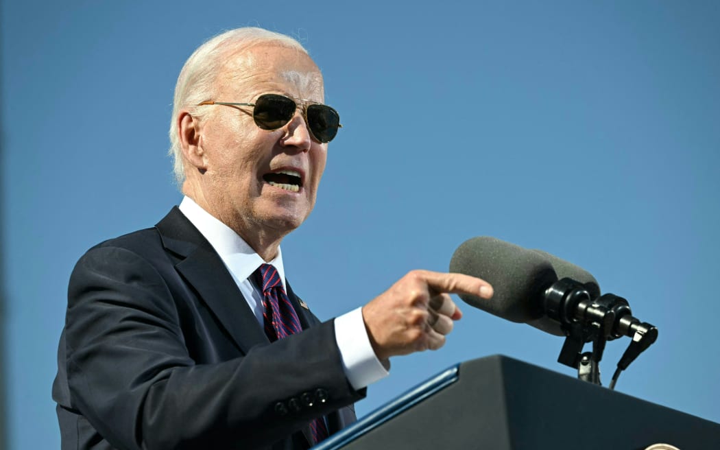 US President Joe Biden gestures as he apologizes for Native American boarding school atrocities at the Gila River Crossing School in the Gila River Indian Community, in Laveen Village, near Phoenix, Arizona on October 25, 2024. - Biden apologized for one of the country's "darkest chapters:" the abduction of Native American children from their families and placement in abusive boarding schools aimed at erasing their culture. The first public apology issued by a sitting US president. From the early 1800s until the 1970s, the US ran hundreds of Indian boarding schools across the country to forcibly assimilate Native children into European settler culture, including conversion to Christianity. (Photo by ANDREW CABALLERO-REYNOLDS / AFP)