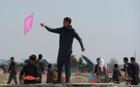 Afghan youths prepare to fly their kites as they celebrate the Nowruz (Noruz), or Persian New Year, in a hilltop overlooking of Kabul on March 21, 2018. / AFP PHOTO / SHAH MARAI
