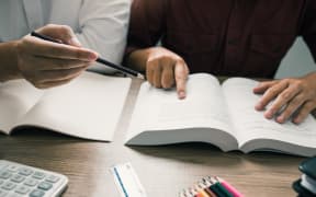Teenager studying at desk and doing homeworks