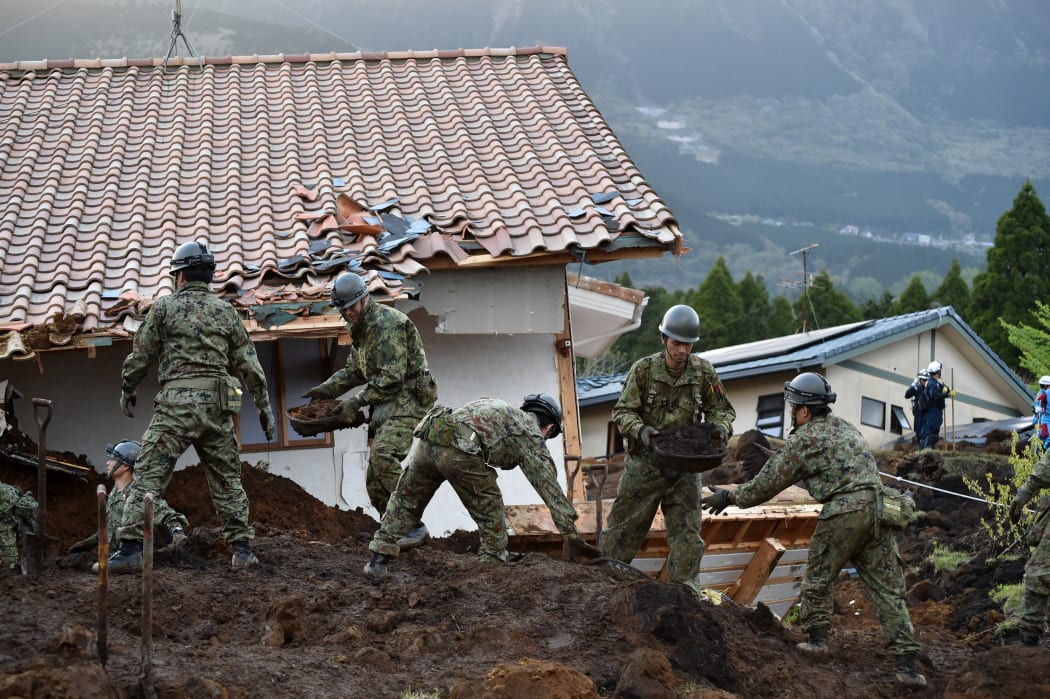 Troops from's Japan Ground Self-Defense Force search for survivors at a landslide site