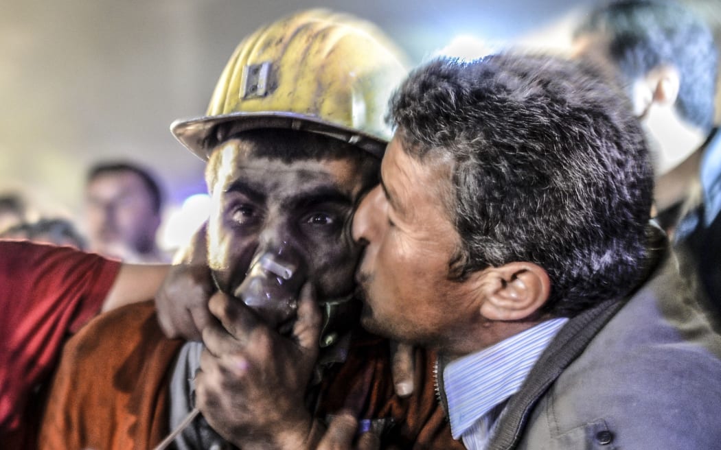 A man with his son rescued of the mine in which more than 250 workers have died after an explosion.