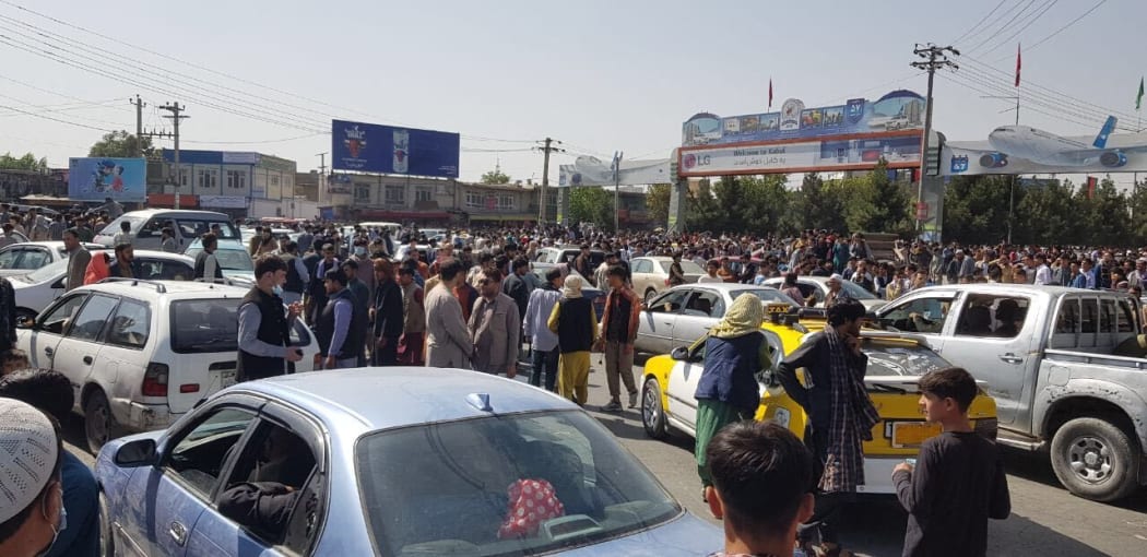 Afghans crowd at the tarmac of the Kabul airport.