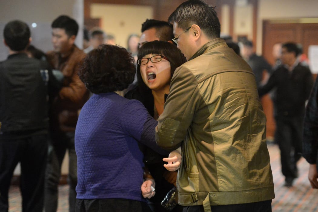 Relatives of passengers on flight MH370 leave a hotel hall in Beijing after being told the plane plunged into the Indian Ocean.