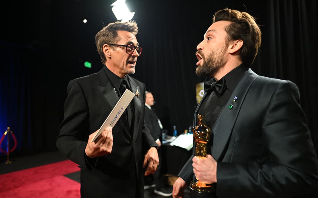 This handout picture courtesy of the Academy of Motion Picture Arts and Sciencies (AMPAS) shows US actor Kieran Culkin (R) with the Oscar for Best Actor in a Supporting Role for "A Real Pain" with presenter US actor Robert Downey Jr (L) during the 97th Annual Academy Awards at the Dolby Theatre in Hollywood, California on March 2, 2025. (Photo by Richard Harbaugh / AMPAS / AFP) / RESTRICTED TO EDITORIAL USE - MANDATORY CREDIT "AFP PHOTO /  RICHARD HARBAUGH / ACADEMY OF MOTION PICTURE ARTS AND SCIENCIES (AMPAS) " - NO MARKETING NO ADVERTISING CAMPAIGNS - DISTRIBUTED AS A SERVICE TO CLIENTS