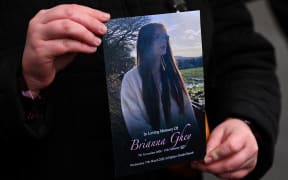 A mourner holds a copy of the order of serves outside St Elphin's Church in Warrington, northern England on March 15, 2023, at the end of the funeral service of murdered transgender teenager Brianna Ghey. 16-year-old Brianna Ghey's body was discovered by members of the public in a park in Culcheth, north of Warrington, after having been fatally stabbed. (Photo by Oli SCARFF / AFP)