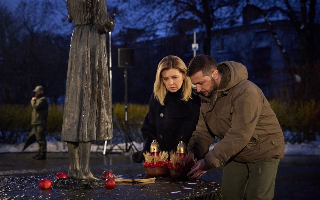 This handout picture taken and released by the Ukrainian Presidential press service on November 26, 2022, shows Ukrainian President Volodymyr Zelensky (R) and his wife Olena paying their respects as they part in a commemoration ceremony in Kyiv at a monument of victims of the Holodomor famine of 1932-33 in which millions died in the Soviet-era famine that many now regard as a genocide ordered by Joseph Stalin. (Photo by HANDOUT / UKRAINIAN PRESIDENTIAL PRESS SERVICE / AFP) / RESTRICTED TO EDITORIAL USE - MANDATORY CREDIT "AFP PHOTO / HANDOUT / UKRAINIAN PRESIDENTIAL PRESS SERVICE " - NO MARKETING NO ADVERTISING CAMPAIGNS - DISTRIBUTED AS A SERVICE TO CLIENTS